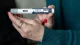 Close-up of a hand holding a Wegovy semaglutide injection pen, prepared for subcutaneous injection.