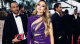 Woman in a purple sequined gown posing on a red carpet with guests and photographers in the background.