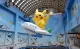 Giant Pikachu balloon riding an airplane balloon in an indoor display