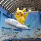 Giant Pikachu balloon riding an airplane balloon in an indoor display
